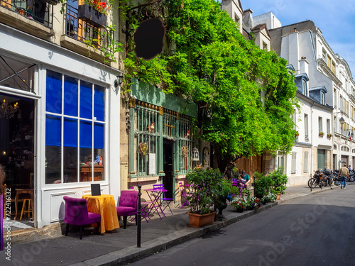 Typical view of street with tables of cafe in Paris, France. Cozy cityscape of Paris. Architecture and landmarks of Paris.