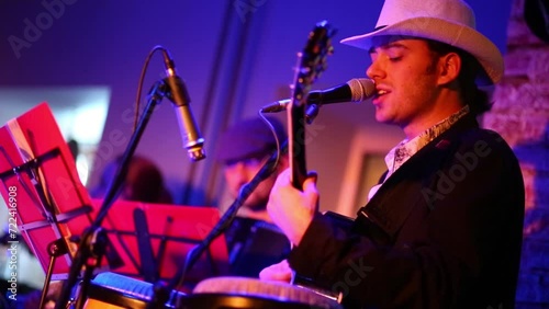Musician of band is playing on guitar at musical bar.