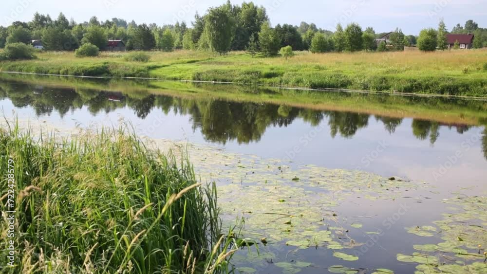 Waterlogged riverside of Tvertsa and houses of village on other side