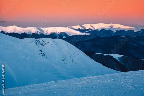 Breathtaking sunset over snow-capped mountains. © Leonid Tit
