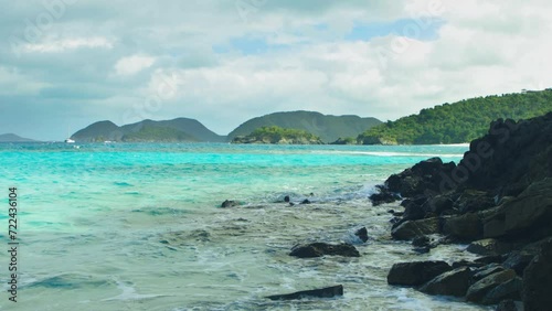 Gorgeous Caribbean view, turquoise water and waves gently splashing on rocky shore on a beautiful sunny day