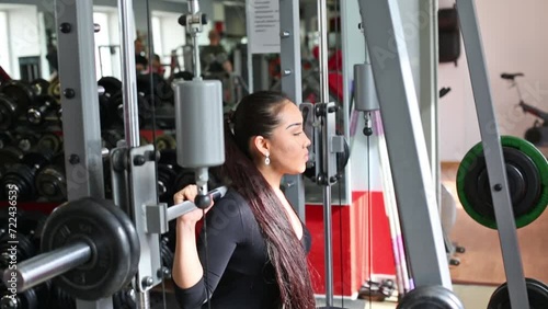 Young asian women is squatting with the weight on multipower system photo