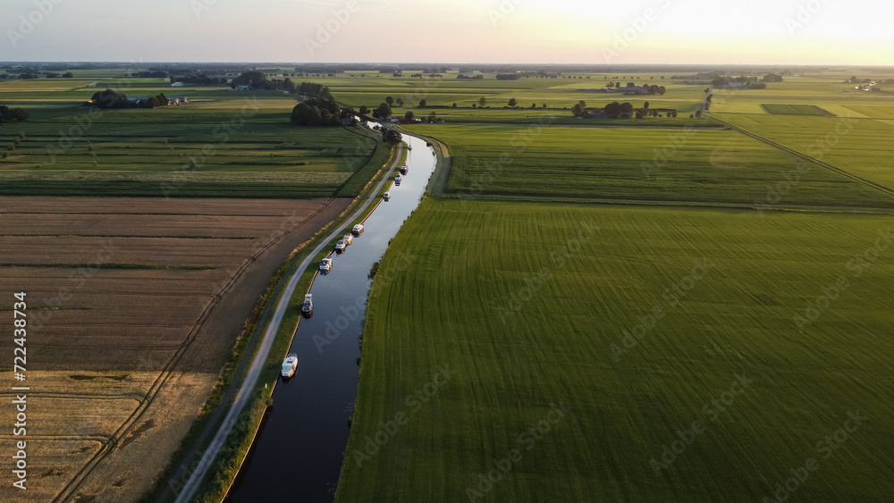 Aerial drone view of the Steenwijkerdiep canal next to farmland, meadow, nature landscape in Steenwijk, The Netherlands. Top view, captured from above with a drone.