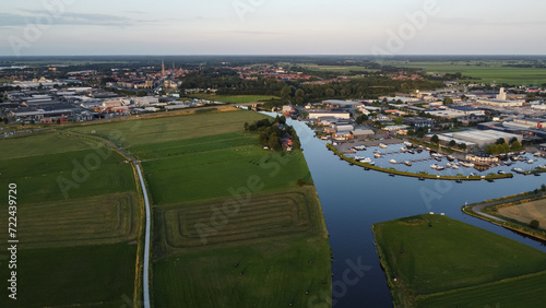 Aerial drone view of harbor, marina and industrial area in Steenwijk, The Netherlands. Company buildings next to canal surrounded by nature farmland meadow landscape captured from above.  photo