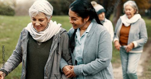Happy, walking and a woman and caregiver in nature for talking, support and relax in the morning. Help, together and a young carer speaking to a senior patient in a park or garden for bonding photo