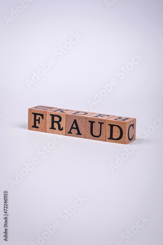 The inscription Fraud inspection made of wooden cubes on a plain background
