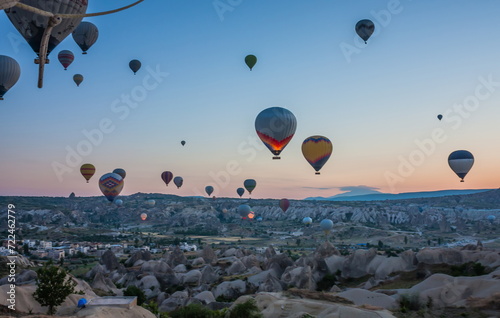 Hot air balloons flying over bizarre rock landscape in Cappadoci