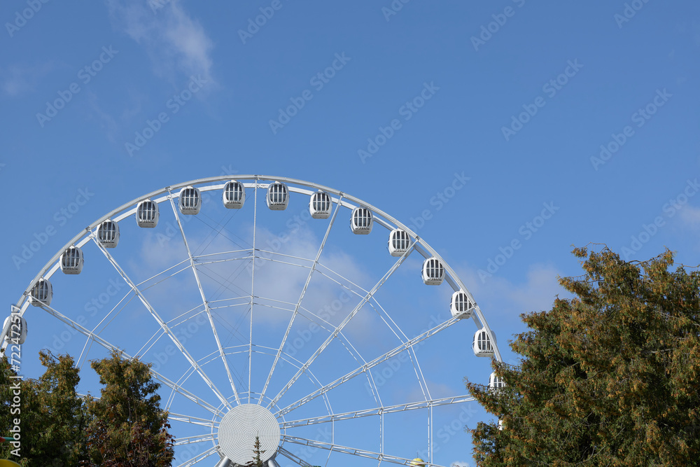Fototapeta premium Celestial Carousel, A Majestic White Ferris Wheel Touching the Skies on a Radiant Day