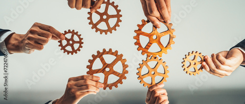Panorama banner of business team join cogwheel in circular symbolize successful group of business partnership and strong collective teamwork unity in workplace with productive efficiency. Shrewd