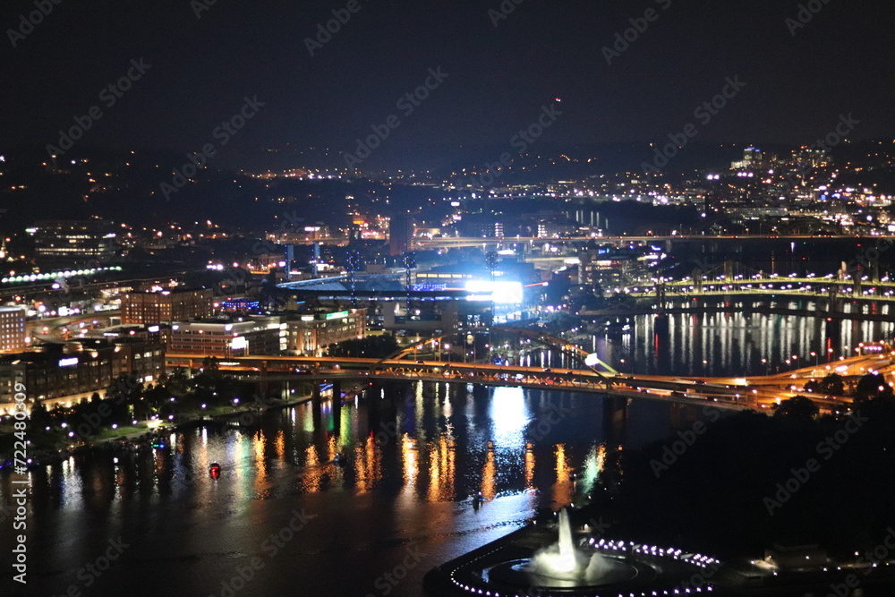 Downtown at night. View of the city lights and landscape. Panoramic view of the bridge and river in the downtown city of Pittsburgh, Pennsylvania —aerial, birds' eye view of downtown and river.