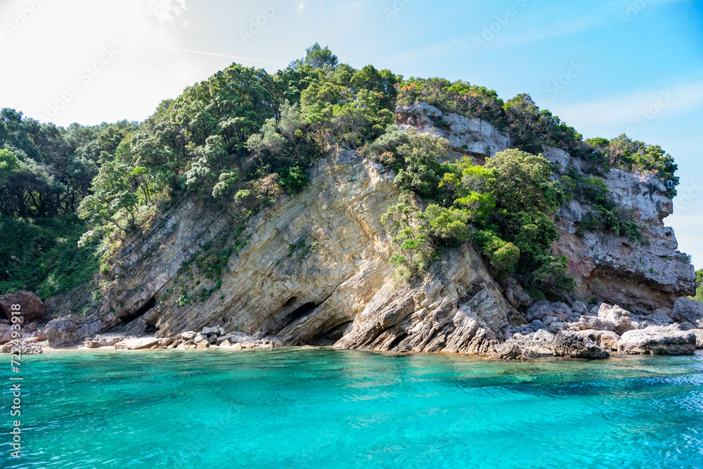 Scenic landscape of Island of Corfu, Greece, western shoreline with cliffs and caves at beach and water line of turquoise or deep blue water with breath taking limestone formations