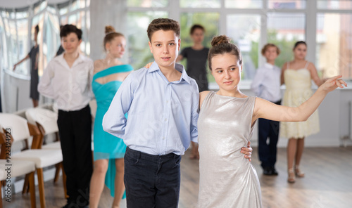 Boy and girl rehearsing social couples ballroom dance in studio