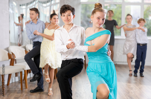 Happy teenage boys and beautiful girls dance a fiery twist dance