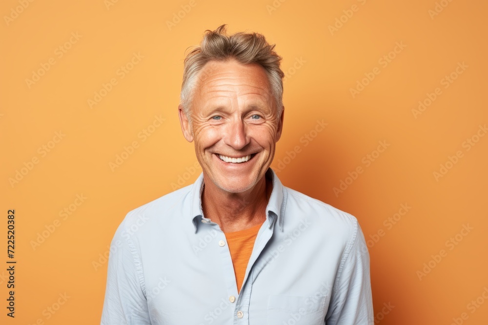Portrait of a happy senior man looking at camera over orange background Portrait of a happy senior man looking at camera over orange background