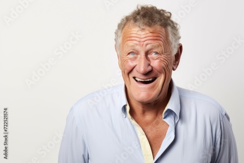 Portrait of a happy senior man laughing against a white background.