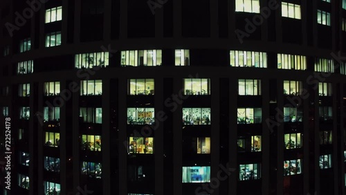 Illuminated windows of office building at winter evening. Aerial view photo