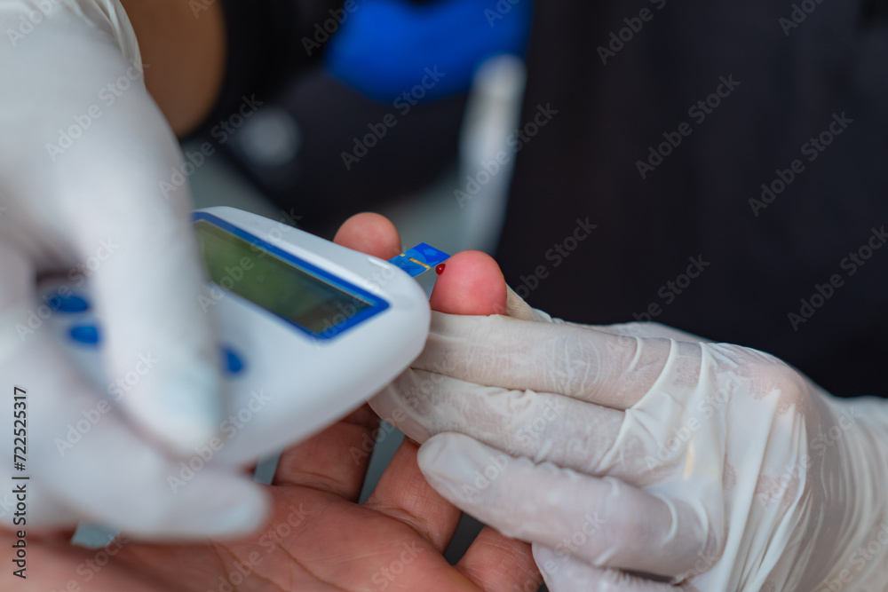 Close up view of medical worker measuring patient's blood with blood glucose meter. Medical concept. Selective focus.