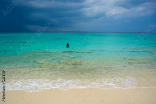 A photo of a young African Caribbean man with dreadlocks refreshing in the azure blue sea.  © Lara Red