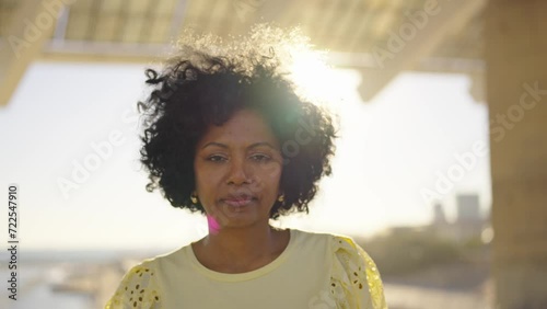 Video zooming out of a proud african woman looking at camera standing outdoors