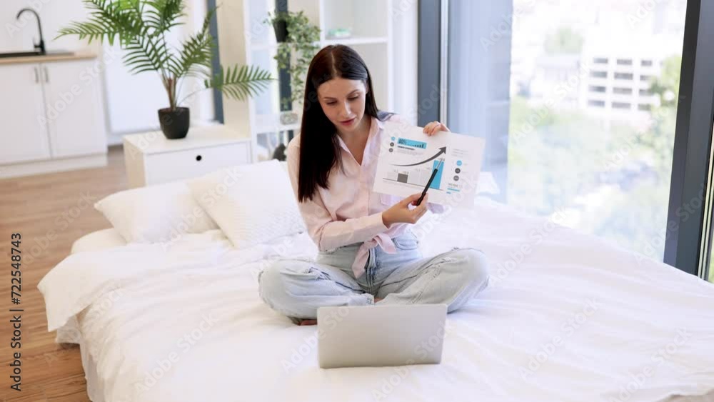 Portrait of young woman manager showing report with graphs and charts while working on modern laptop. Caucasian brunette working remotely enjoying online chatting with colleagues from home . Portrait of young woman manager showing report with graphs and charts while working on modern laptop. Caucasian brunette working remotely enjoying online chatting with colleagues from home .