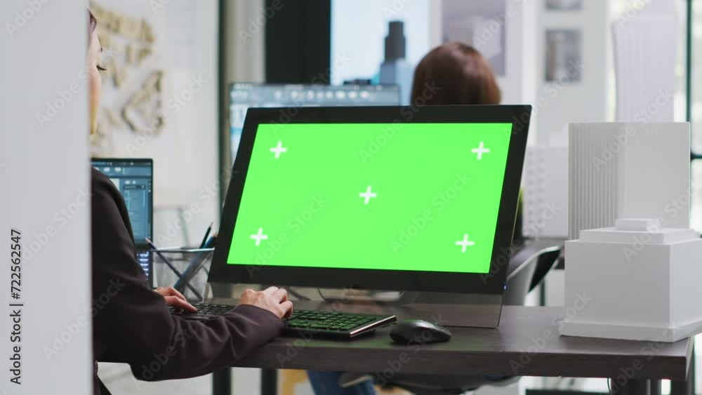 Cad specialist using computer with greenscreen at office desk, reviewing pc display with isolated copyspace layout in unicorn business coworking space. Architect blank chromakey template on monitor. Cad specialist using computer with greenscreen at office desk, reviewing pc display with isolated copyspace layout in unicorn business coworking space. Architect blank chromakey template on monitor.