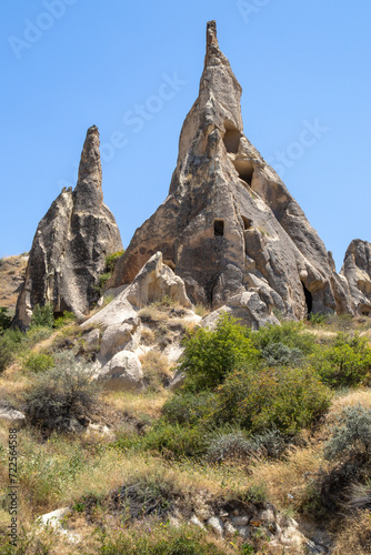 Striking Cappadocia spires against a clear blue sky, perfect for articles on geological history, travel guides, or as an evocative background for storytelling.