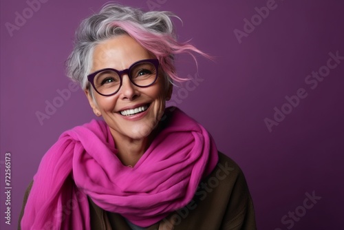 Portrait of a happy senior woman with pink hair wearing glasses and a scarf