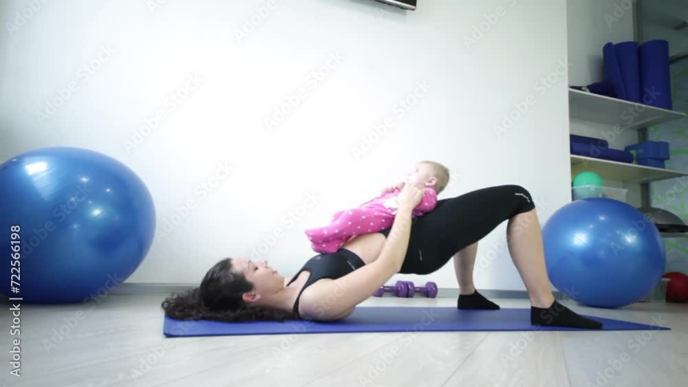 mother with her daughter doing exercise raising and lowering her hips mother with her daughter doing exercise raising and lowering her hips