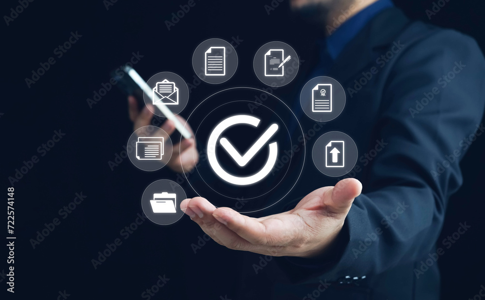 Businessman using smartphone with virtual correct sign or tick mark with document icon for approve quality assurance and guarantee concept, online approve paperless and quality assurance concept. Businessman using smartphone with virtual correct sign or tick mark with document icon for approve quality assurance and guarantee concept, online approve paperless and quality assurance concept.