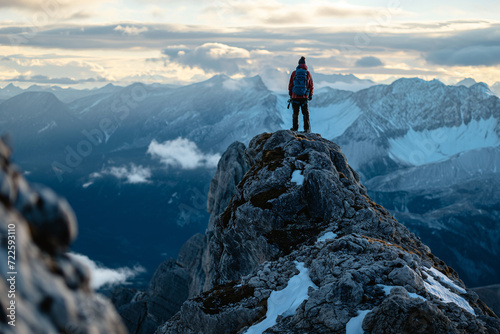 Person Standing on Snow-capped Mountain Peak © Ilugram