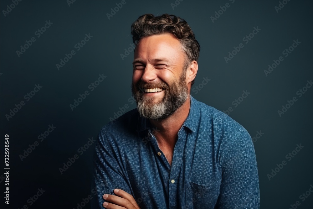 Portrait of a handsome mature man laughing against dark blue background. Portrait of a handsome mature man laughing against dark blue background.