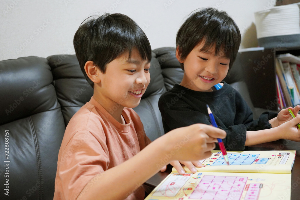 Two brothers happily studying together Two brothers happily studying together