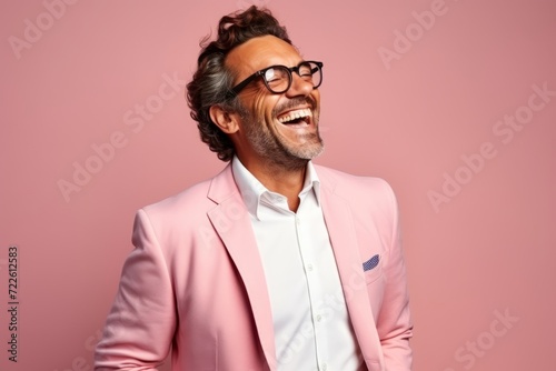 Portrait of a smiling mature man in glasses and a pink suit.