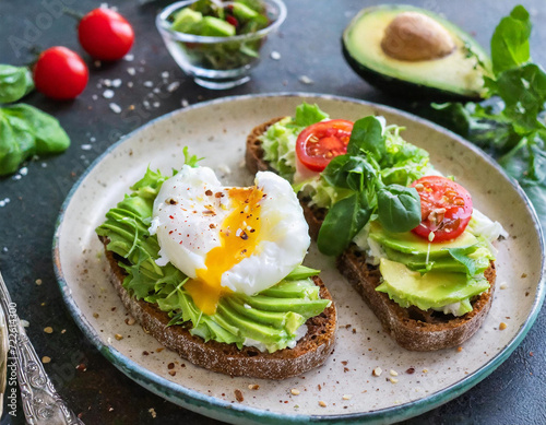 A delicious breakfast or tapas featuring crispy wholemeal toast with poached eggs and mashed avocado.