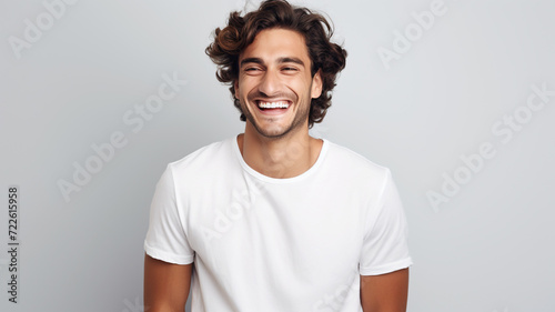 Happy smiling young adult man on a solid background photo