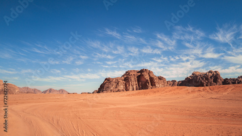 Wadi Rum  Jordan  Scenic view of Arabic Middle Eastern desert against clear blue sky with sand tracks in foreground. Mountain in background. Copy space no people