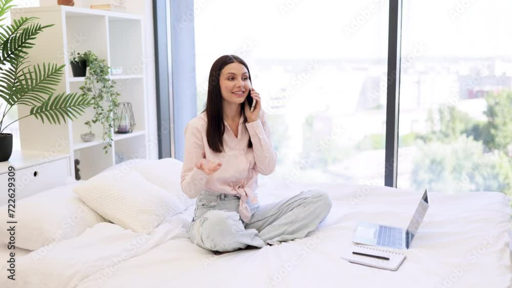 Beautiful woman relaxing on bed at home and using modern smartphone for talking with family. Caucasian brunette using modern devices enjoying break from work for business negotiations on weekend. Beautiful woman relaxing on bed at home and using modern smartphone for talking with family. Caucasian brunette using modern devices enjoying break from work for business negotiations on weekend.