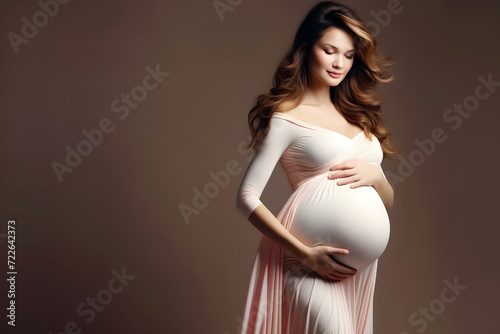 beauty of pregnancy. The subject, elegantly draped in a flowing pink gown, stands in a graceful pose. Beauty young mom