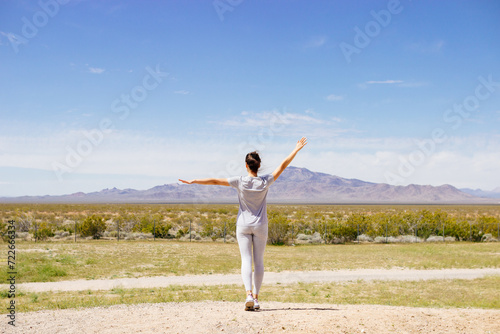 A young girl in a gray T-shirt walks through the Arizona desert on a summer sunny day