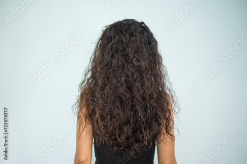 person woman body part showing long curly hairstyle