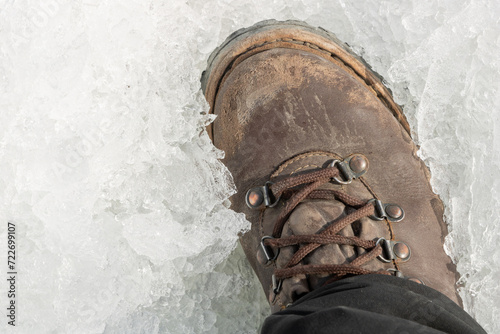 bota de montanhismo robusta sobre gelo frio photo