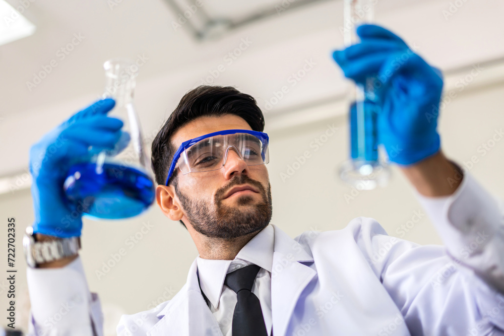 Professional scientist man research and working doing a vaccine while making analyzing for coronavirus vaccine mixing liquid in test tube with inscription Covid-19.Man looking sample coronavirus Professional scientist man research and working doing a vaccine while making analyzing for coronavirus vaccine mixing liquid in test tube with inscription Covid-19.Man looking sample coronavirus