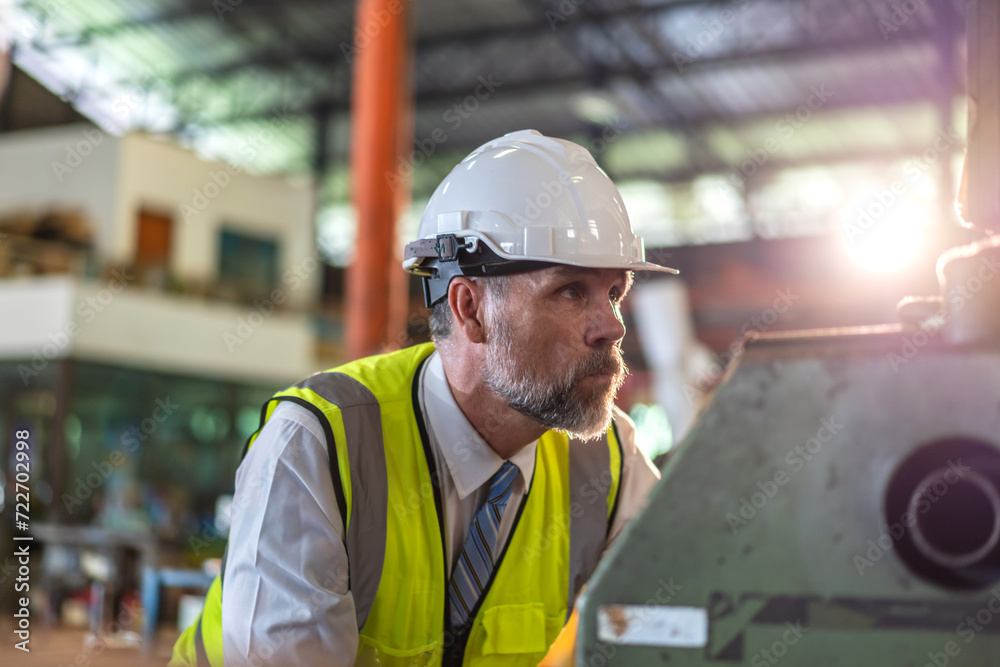 Professional labor machanic engineer technician worker senior man industrial wearing safety uniform working control with heavy machine in manufacturing factory production line.business industry Professional labor machanic engineer technician worker senior man industrial wearing safety uniform working control with heavy machine in manufacturing factory production line.business industry