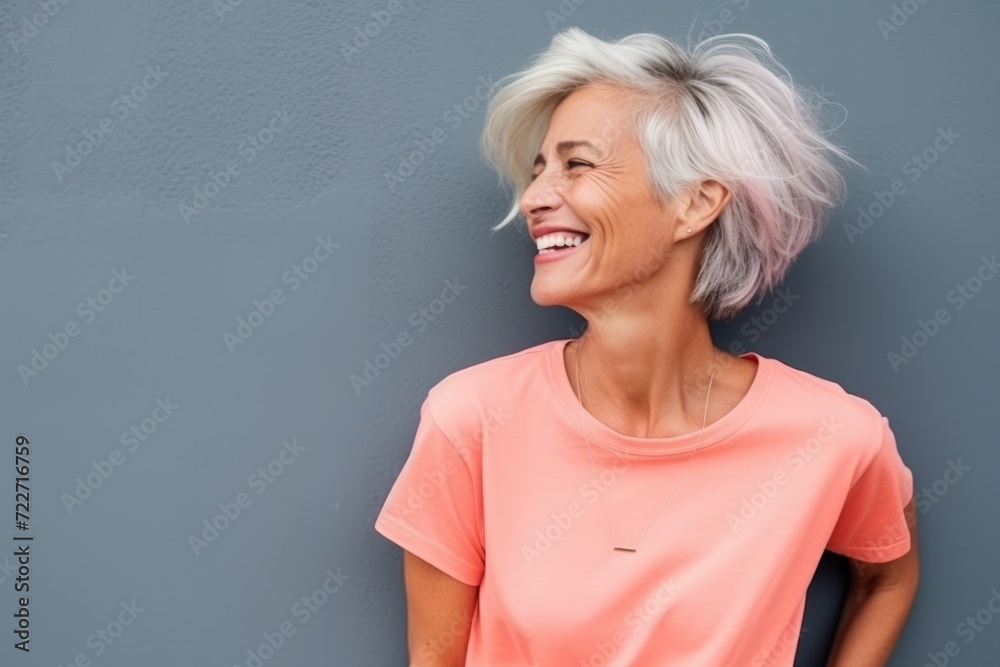 Portrait of a happy senior woman laughing against grey background with copy space Portrait of a happy senior woman laughing against grey background with copy space