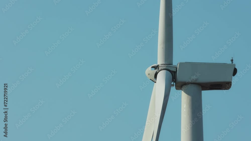 Close up of wind turbine spinning in windmills farm for energy production Close up of wind turbine spinning in windmills farm for energy production