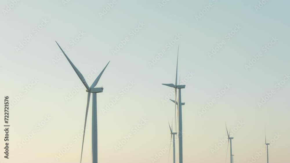 Close up of wind turbine spinning in windmills farm for energy production Close up of wind turbine spinning in windmills farm for energy production