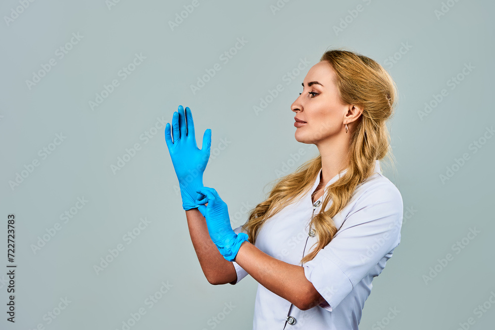 a female doctor in a white coat and blue gloves a female doctor in a white coat and blue gloves