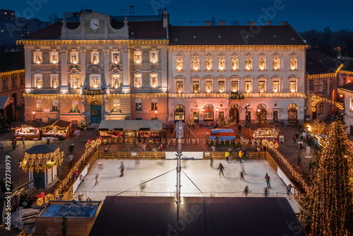 Obraz na płótnie Budapest, Hungary - Aerial view of the Christmas market and ice rink on Szentlelek square, Obuda at dusk. Decorative illuminated shops, festive decoration and Christmas signs on the streets of Buda w salonie