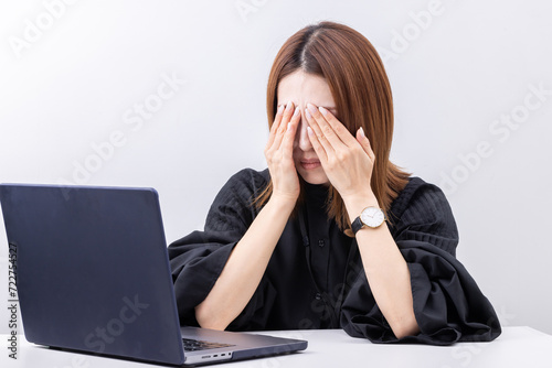 パソコンの前で目を押さえる女性 eye strain