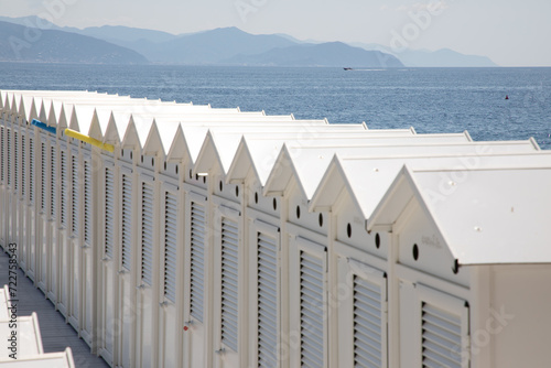 Fototapeta Naklejka Na Ścianę i Meble -  Beach cabins on Genoa beach changing rooms white cabin sea dressing room lockers in italy